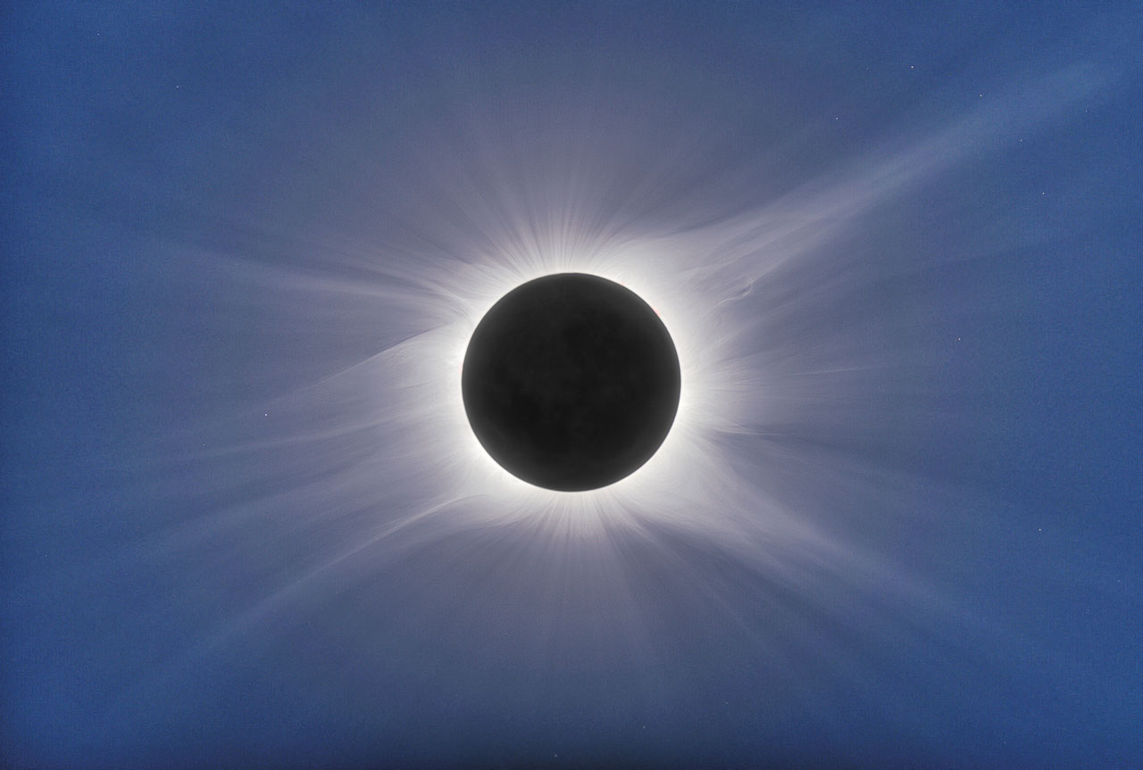 The solar corona is visible at eclipse totality as the moon covers the disk of the sun