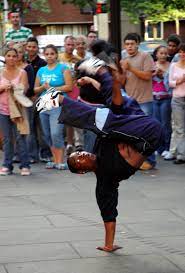 photo of a break dancer with people watching in the background