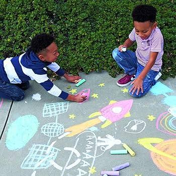 two young boys making chalk drawings on sidewalk