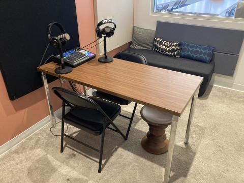 Image of a table inside the the Podcast Studio.  The table has podcasting equipment including headphones, microphones, and a Rodecaster Pro.