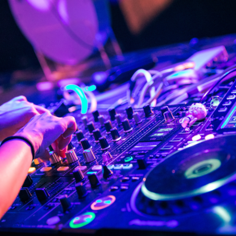 DJ mixing music with colorful lights