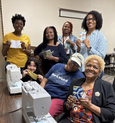 Group of smiling adults at the Cherokee Library who are showing their finished project.