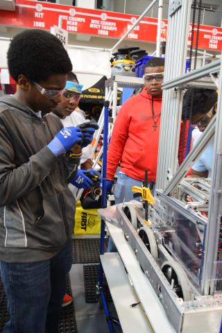 Four teens fixing a robot