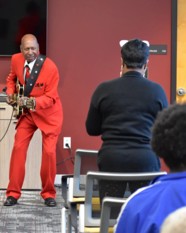 Kenneth Jackson playing guitar for a fan. 