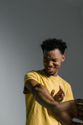 A frighten man with a bug on his arm