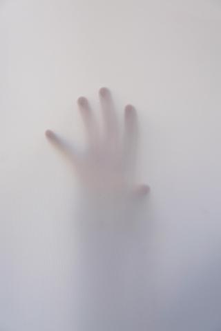 a hand behind a translucent screen