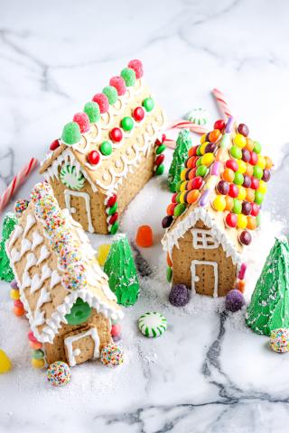 photo of three decorated graham cracker gingerbread houses