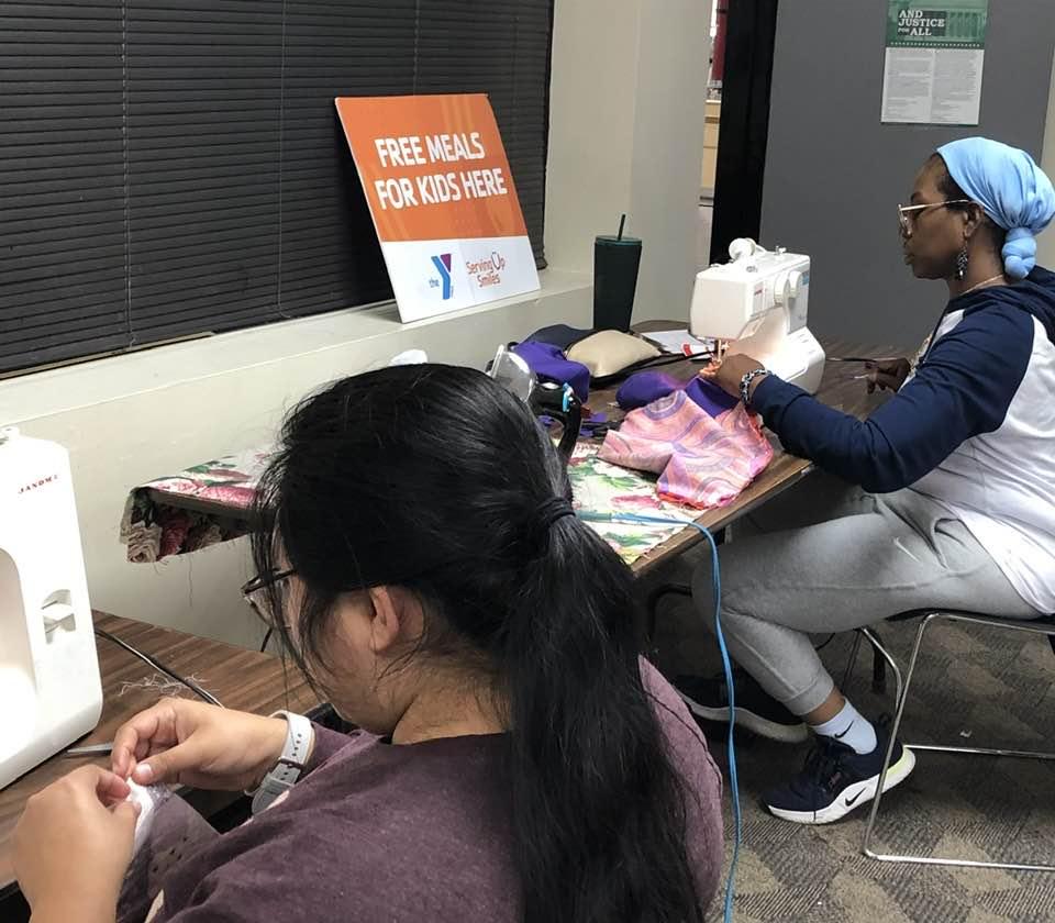 Two adults using sewing machines at the Cherokee Library.