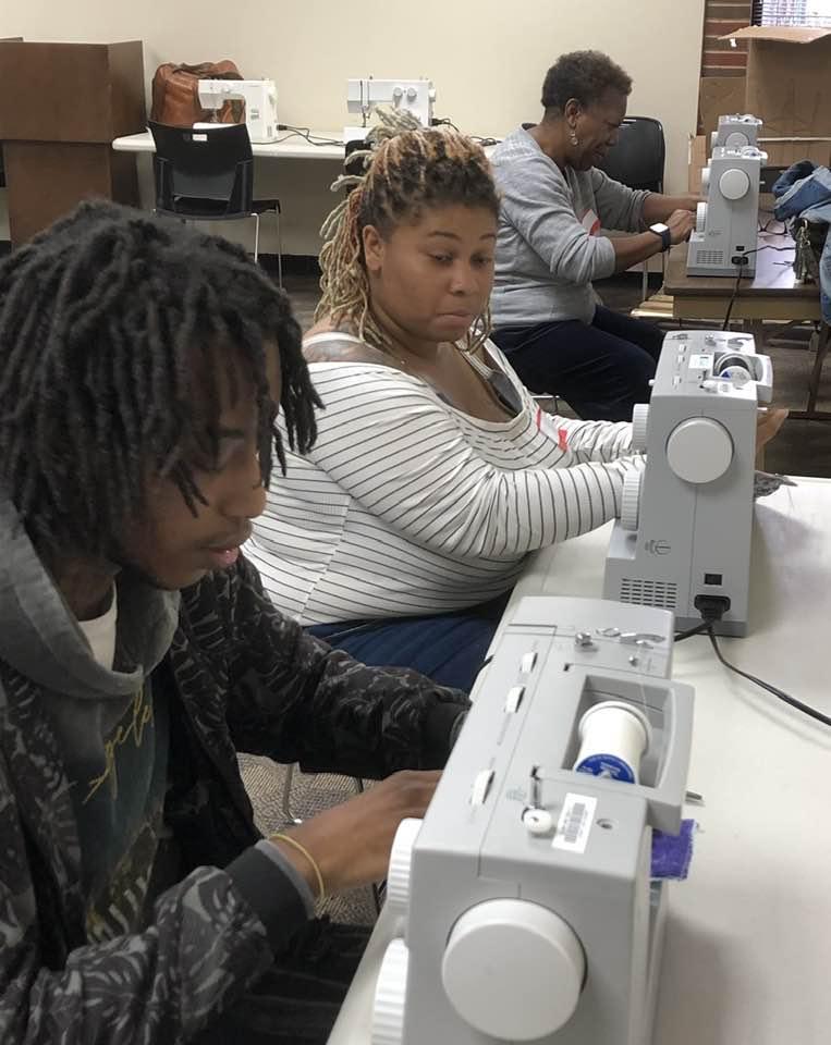 Two adults using sewing machines at the Cherokee Library.