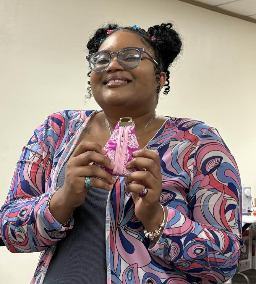 Excited woman at Cherokee Library holding up finished project with a big smile.