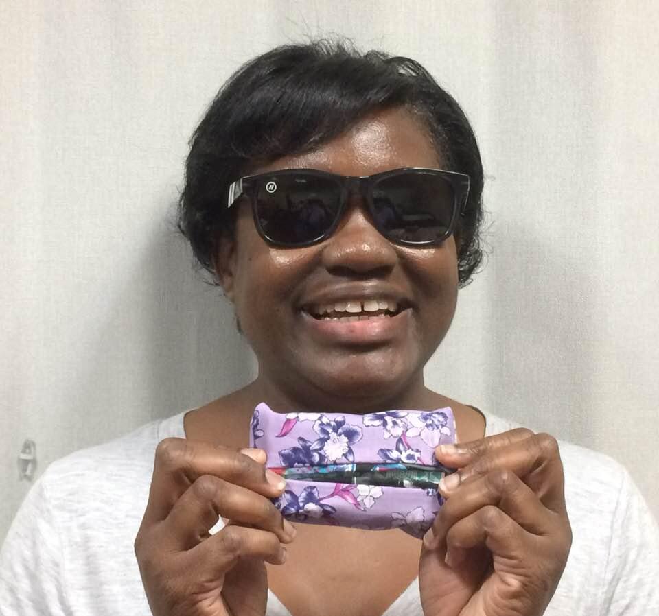 Young woman with sunglasses holding a small sewn project.