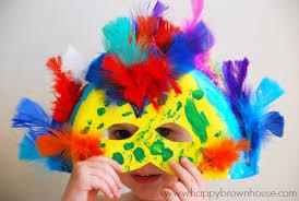 photo of a child covering their face with a decorated paper plate mask