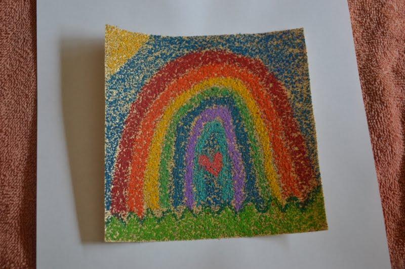 photograph of a child's drawing of a rainbow on sandpaper