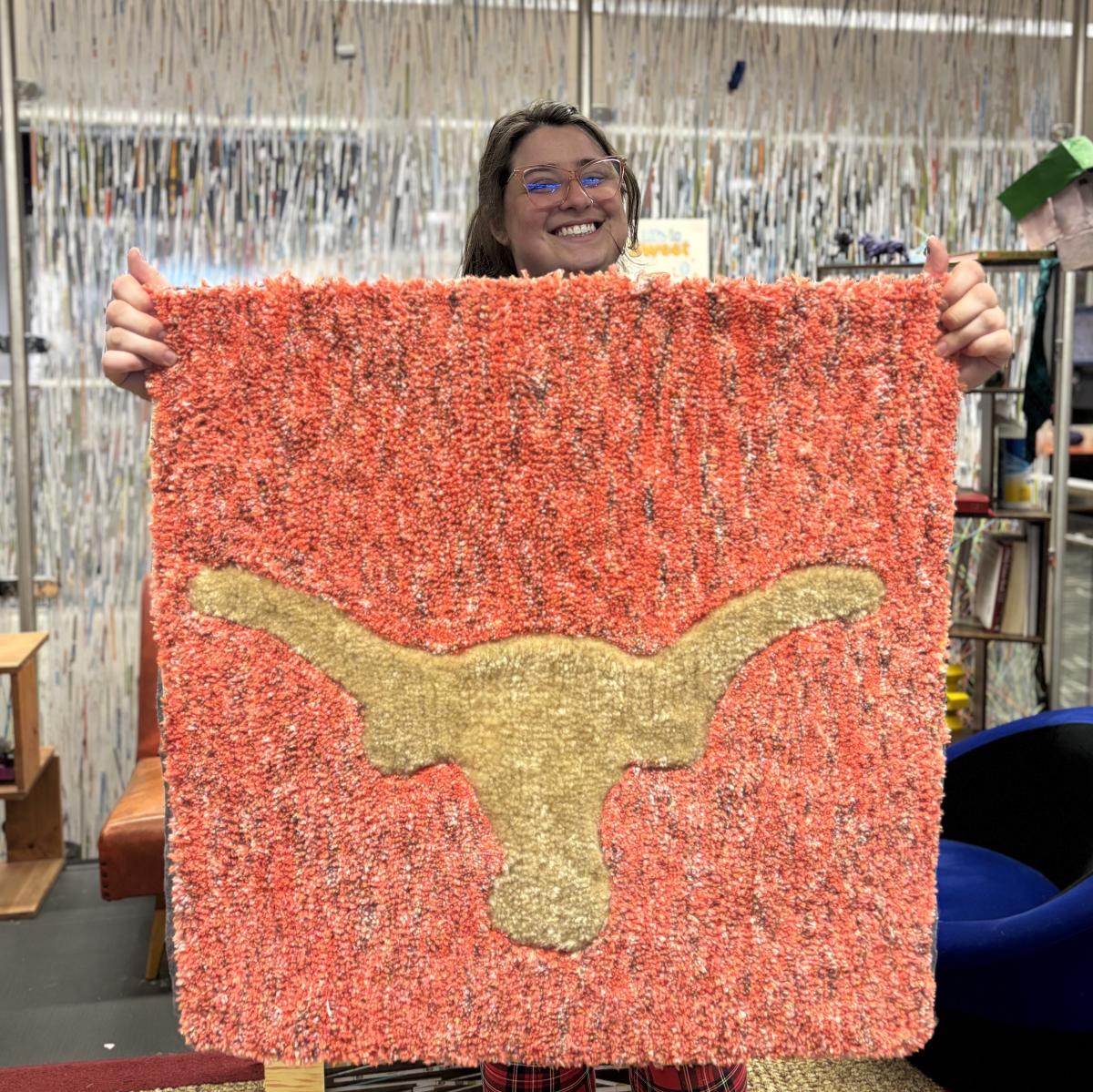 Woman holds a handmade rug