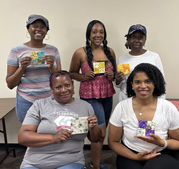 Group of smiling adults at the Cherokee Library who are showing their finished project.